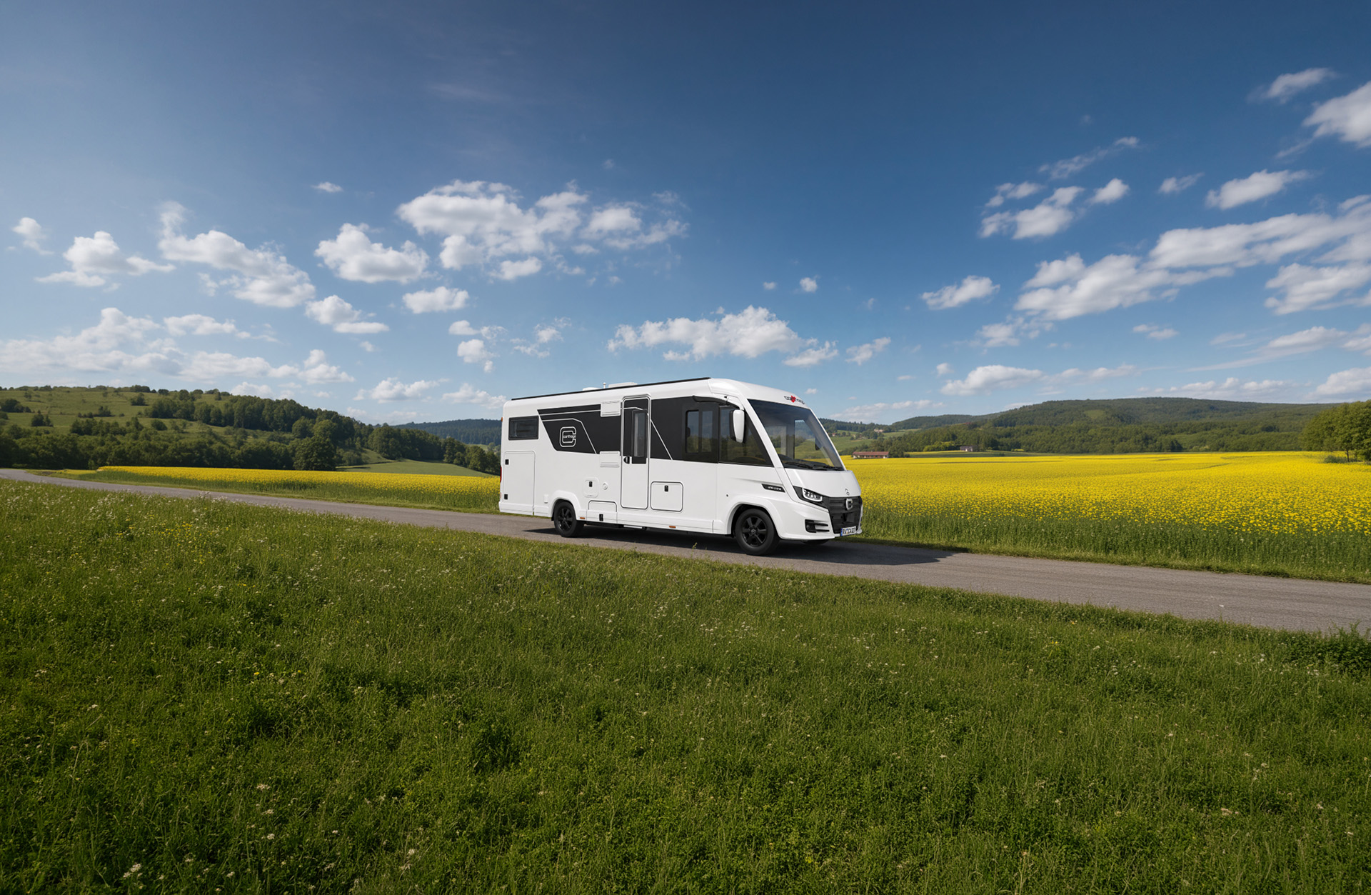 Carthago chic c-line, vollintegriertes Wohnmobil auf einer Landstraße vor gelbem Feld und Hügellandschaft